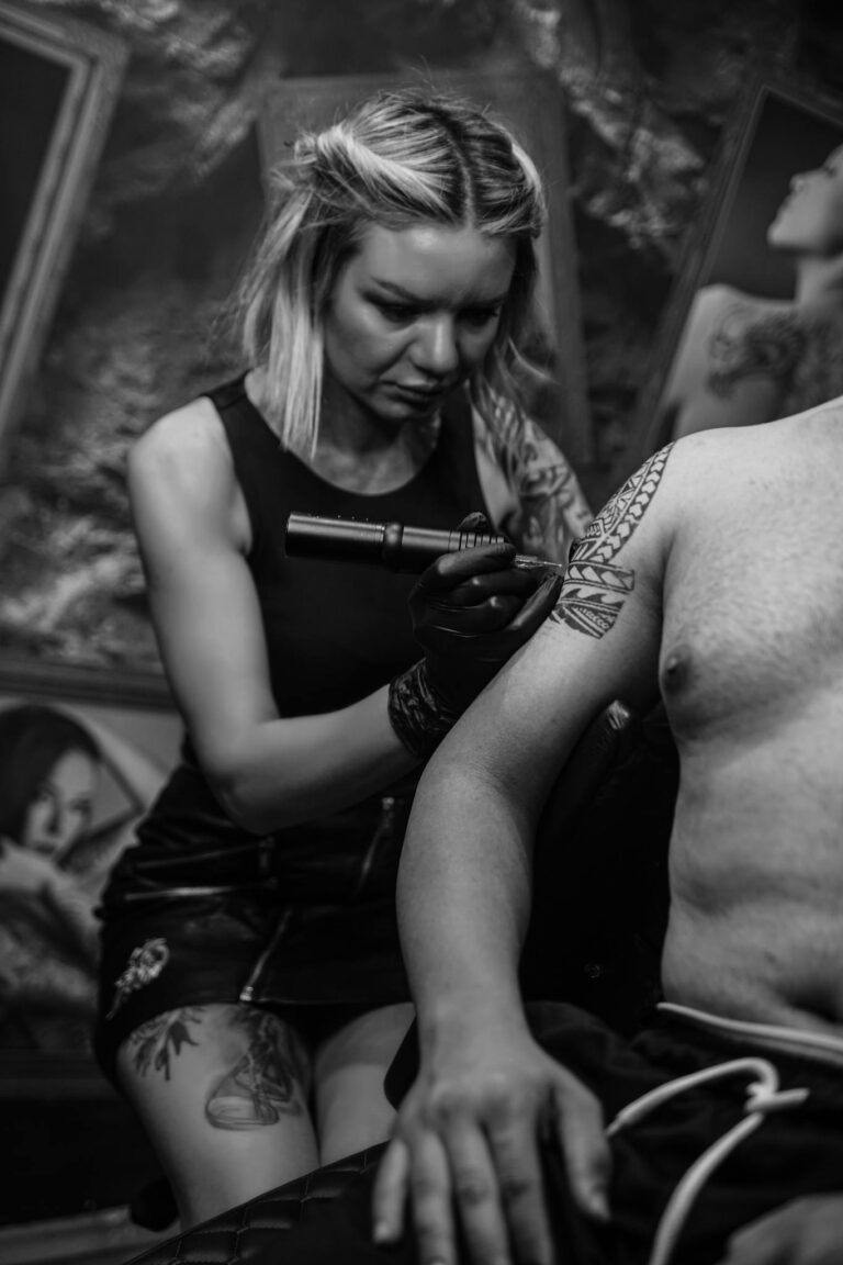 A focused tattoo artist works on a client's arm in an İstanbul studio.