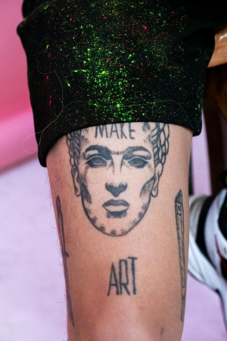 Close-up of a Frida Kahlo inspired tattoo on a leg featuring artistic elements.