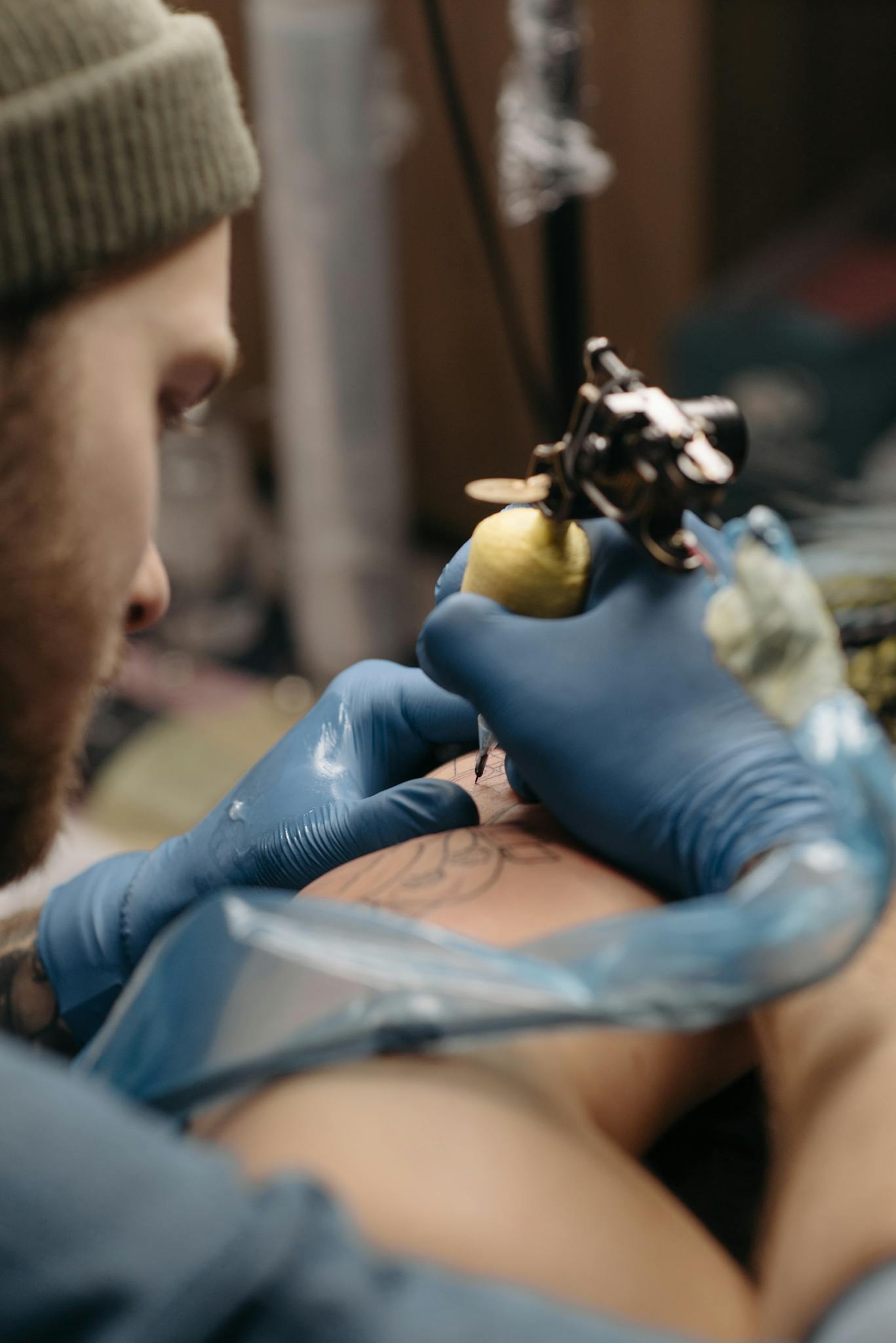 Close-up of a tattoo artist working on a tattoo design in a studio setting.