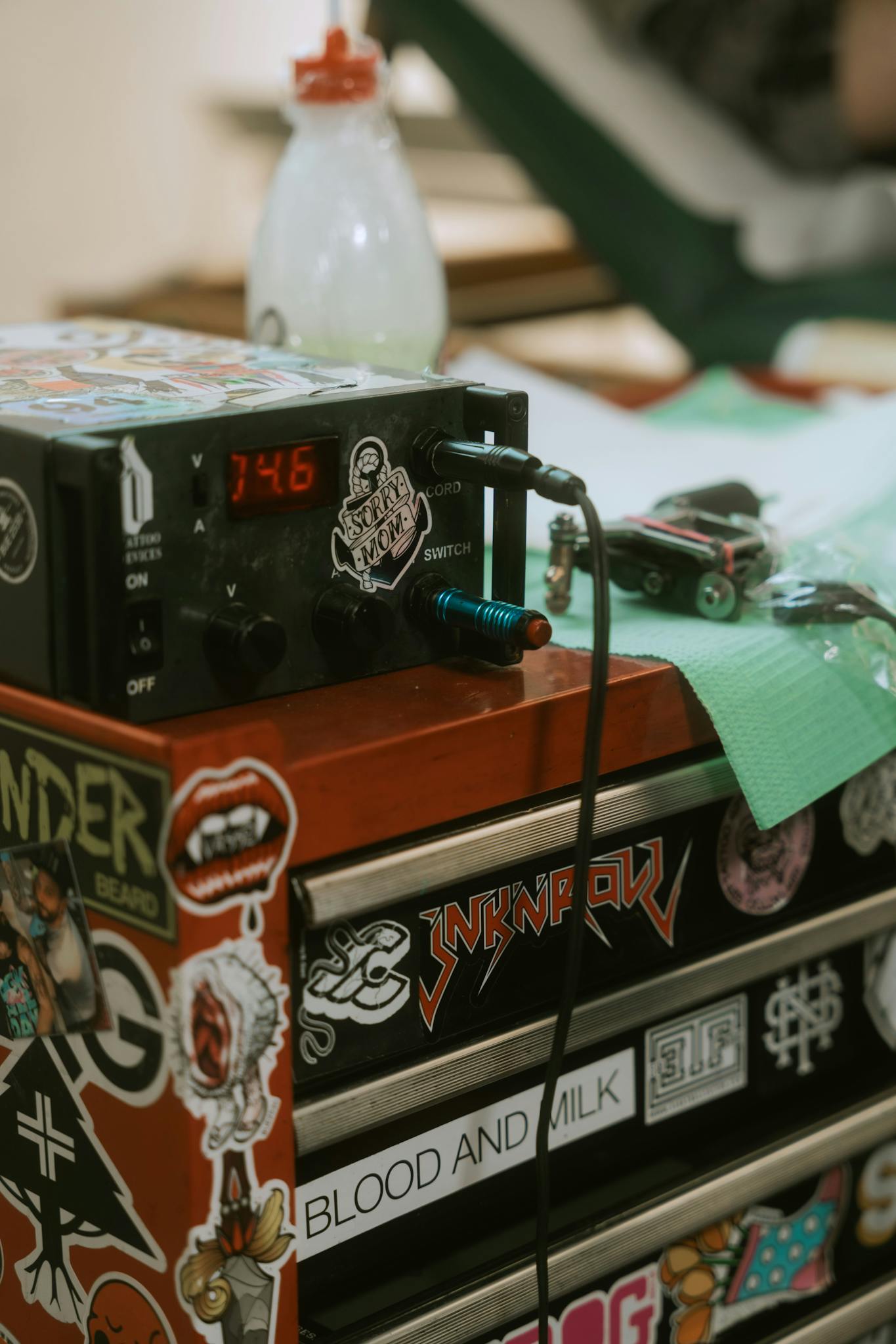 Tattoo equipment with vibrant stickers and colorful decor in a studio setting.